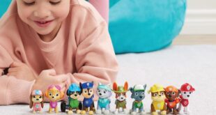 Ein Mädchen liegt auf dem Fußboden und lächelt über ihre Paw Patrol Action Pack Pups Figuren