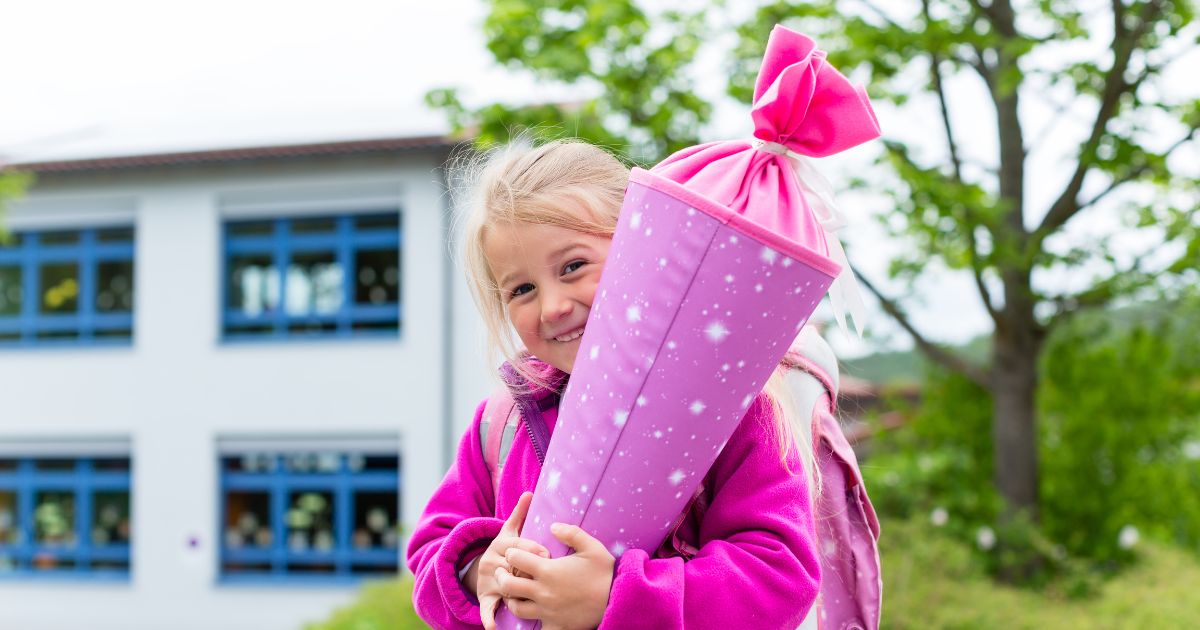 lächelndes Mädchen mit einer Schultüte im Arm