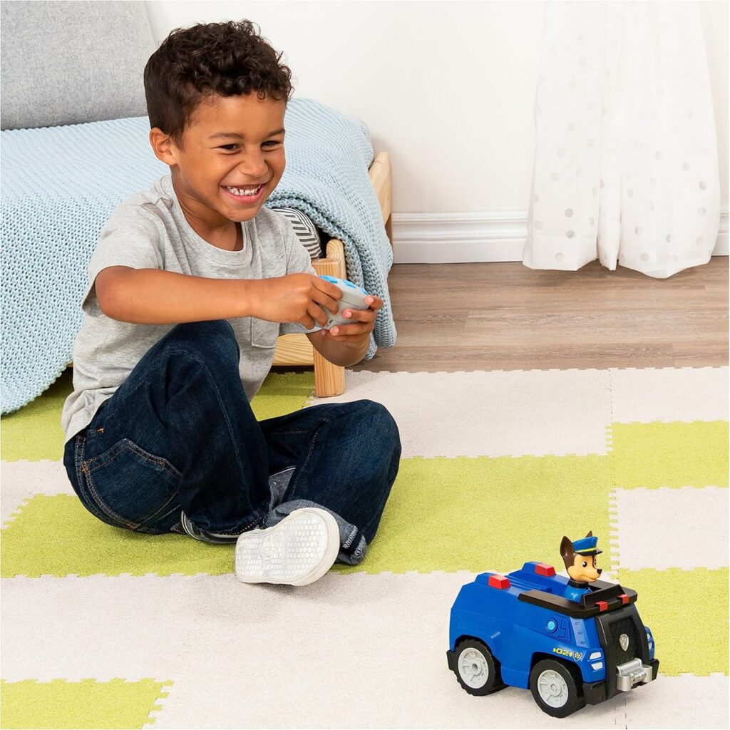 strahlender Junge spielt mit seinem Paw Patrol ferngesteuertem RC Auto